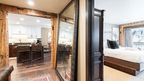 Une chambre à coucher moderne avec un grand lit, un miroir à cadre en bois et une vue sur la ville.
