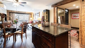 Une cuisine moderne dotée d’un îlot central, de meubles en bois et d’un coin repas avec un canapé et des chaises.