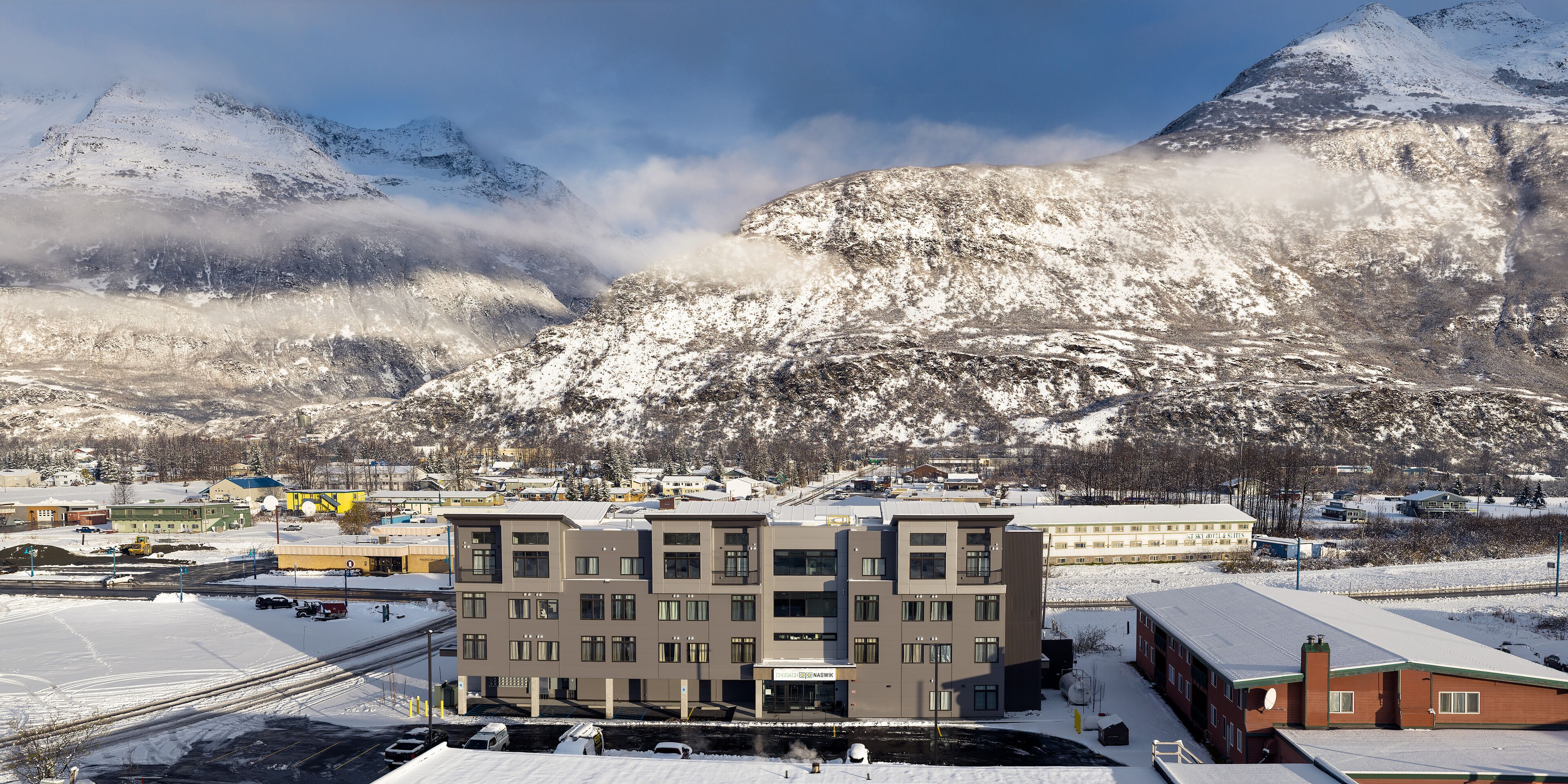 A multi-story building with a flat roof, located in a snowy mountainous area.