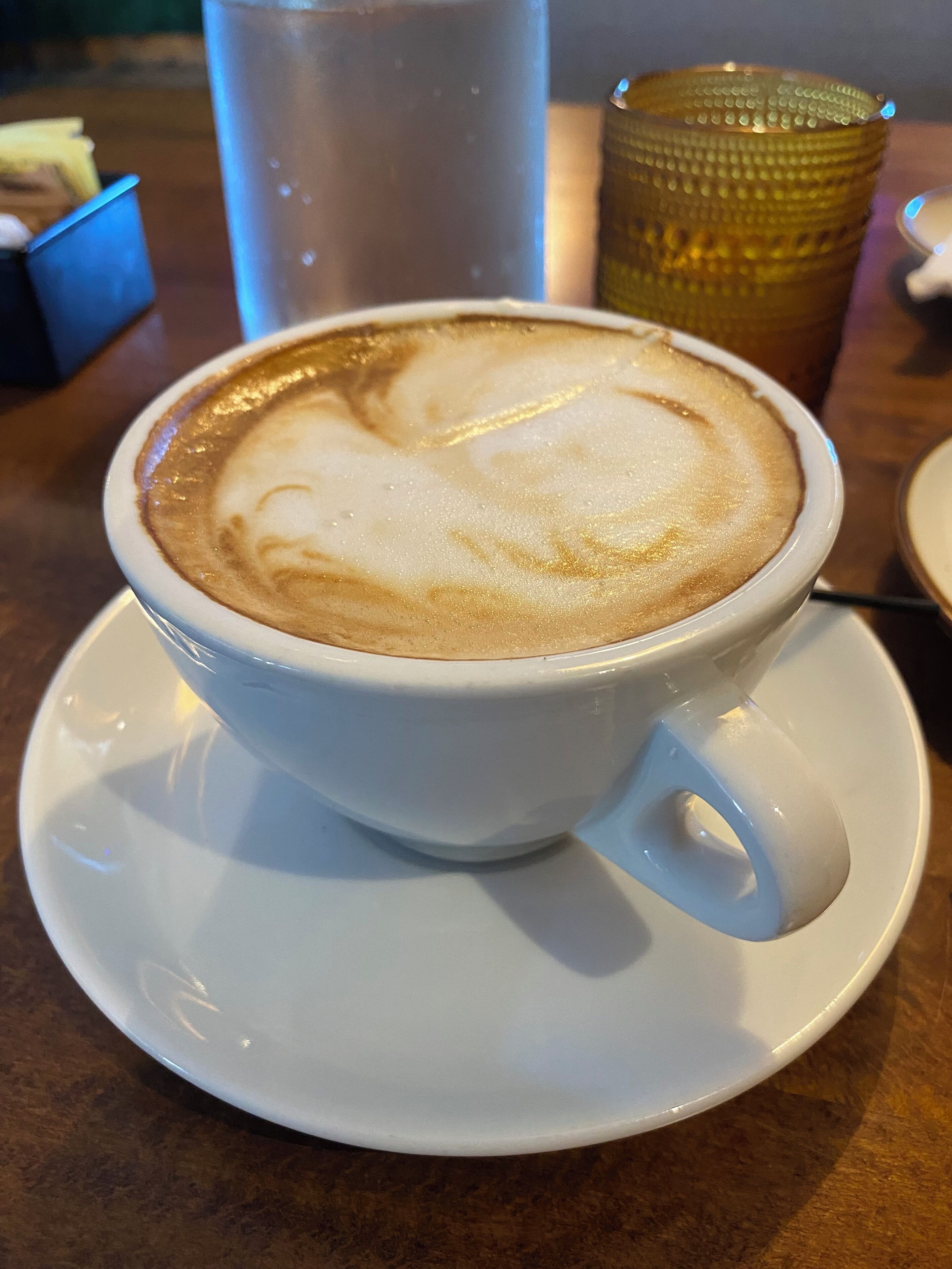 A cup of coffee with latte art on a saucer.