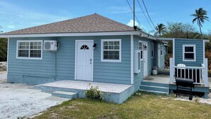 Ein kleines, eingeschossiges Haus mit Veranda und Garage.