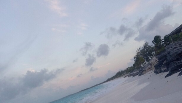 Ein Strand mit blauem Himmel und ruhiger See.