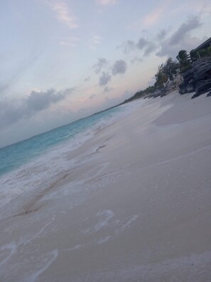 Une plage avec un ciel dégagé et une mer calme.