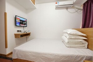 A hotel room with a bed, a TV on a stand, an air conditioning unit, and a wooden shelf. - Shengsi medlar island juyuange fisherman's hostel (Shengsi)