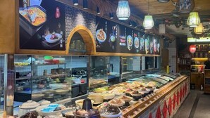 Een buffetgedeelte met diverse gerechten en een keuken op de achtergrond.
