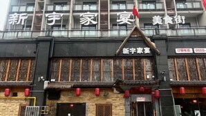 Een gebouw in traditionele Chinese bouwstijl, met houten lattijngedeelde ramen en een betegeld dak.