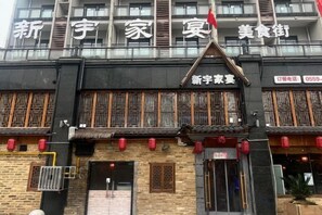 Un bâtiment présentant des éléments d’architecture chinoise traditionnelle, notamment des fenêtres à croisillons en bois et un toit recouvert de tuiles.