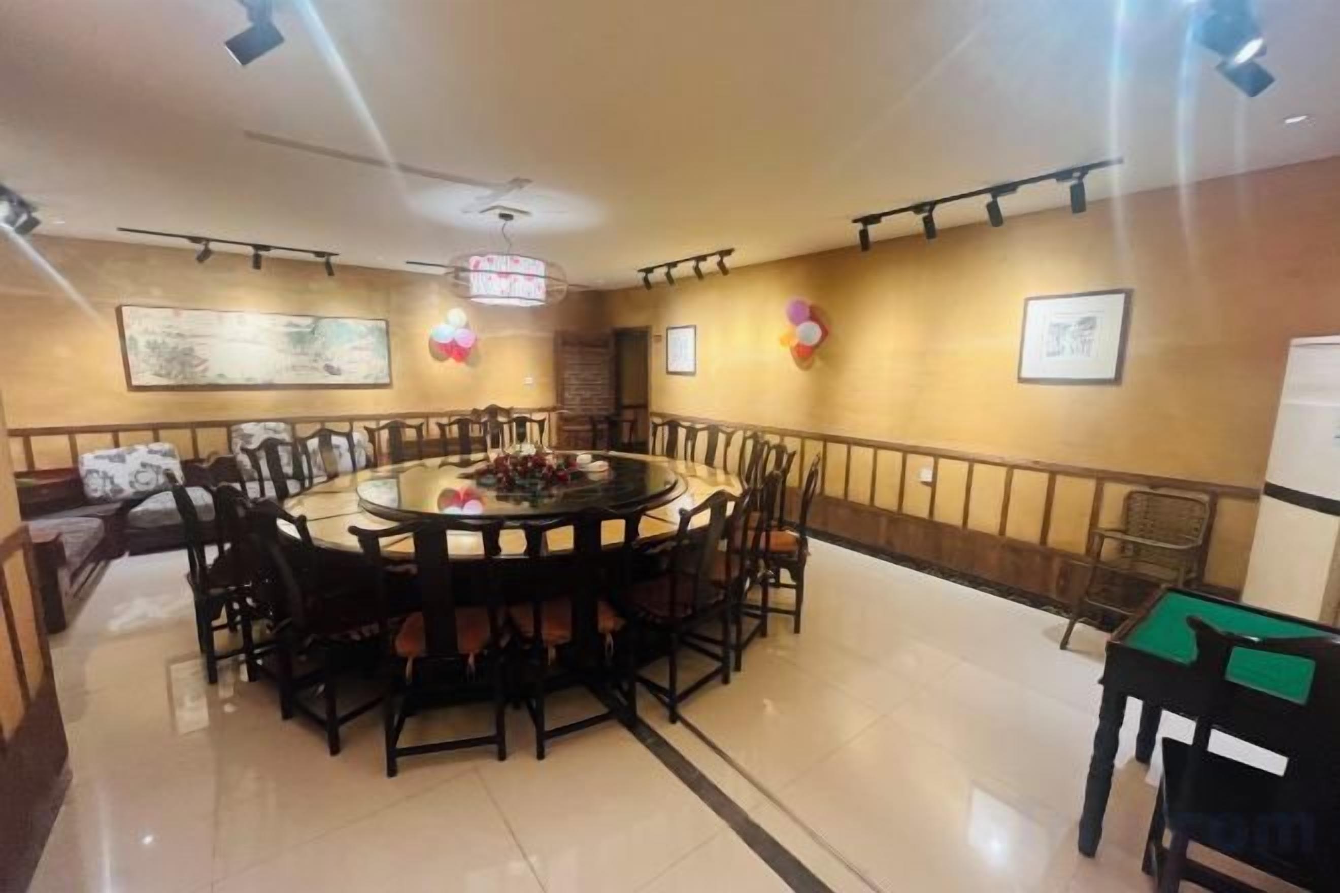 A conference room with a round table, chairs, and a whiteboard.