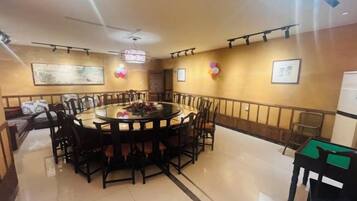 A conference room with a round table, chairs, and a whiteboard.