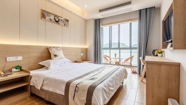 Een moderne hotelkamer met een groot bed, nachtkastje en een klein bureau.