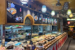 Une présentation de plats variés, avec un espace cuisine en arrière-plan.