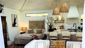 A spacious living area with a large sofa, a coffee table, and a kitchen in the background. - Ojai Serenity Retreat - Tranquil Valley Escape (Ojai)