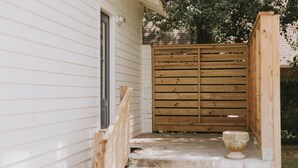 Une porte en bois mène à une maison avec un escalier en béton.