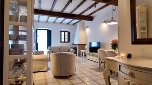 A cozy living room with a fireplace, a television, and a dining area with a table and chairs.