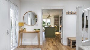 A modern interior with a wooden floor, a central island, and a view to the outside. - Pembroke Cottage -  A short stroll from Cartmel Village (Cartmel)