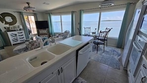 Una cocina con una isla grande, un comedor y vistas al mar.