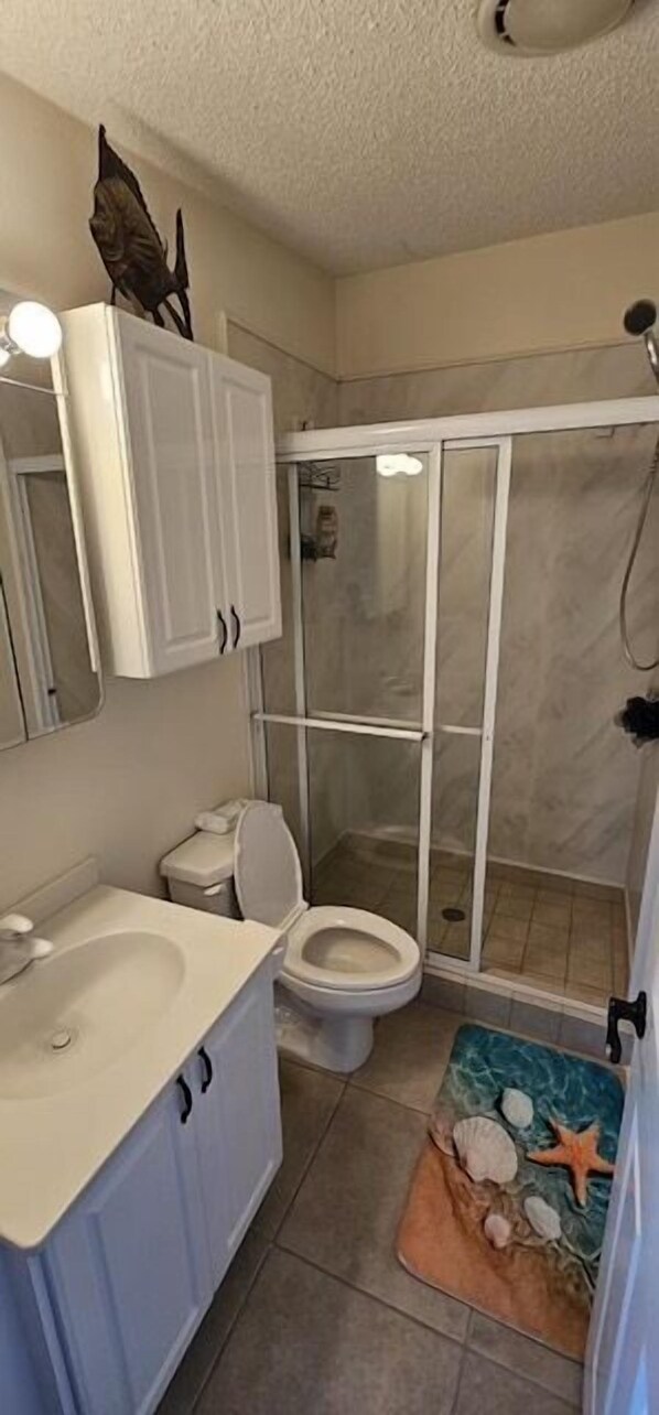 A bathroom with a toilet, sink, and shower. - Oceanfront Dream Home - VO048 (Cudjoe key)