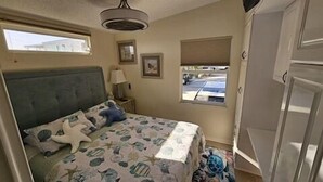 Un dormitorio con cama, ventana, lámpara y armario.