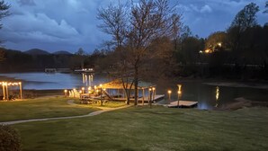 Une terrasse au bord du lac avec des rampes en bois, un espace pique-nique et un kiosque.