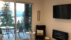 Een moderne woonkamer met een bank, salontafel en een aan de muur bevestigde televisie.