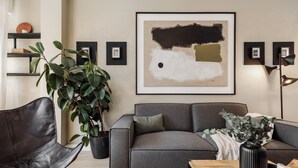 A modern living room with a grey sofa, a black leather chair, and a large abstract painting on the wall. - Holzer - 2 bedrooms in Sant Antoni (Barcelona)