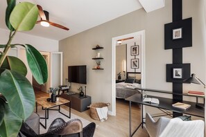 Een moderne woonkamer met een televisie, een eethoek en een slaapkamer.