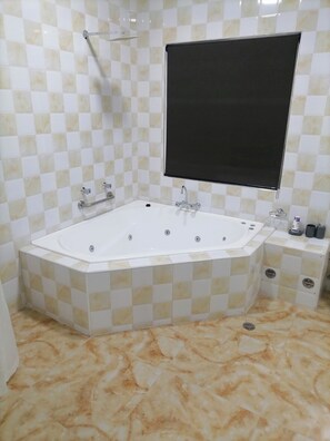 A bathroom with a freestanding bathtub, a showerhead, and a sink with a mirror above it.