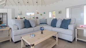 Una sala moderna con un sofá modular, una mesa de centro de madera y un globo terráqueo como adorno.