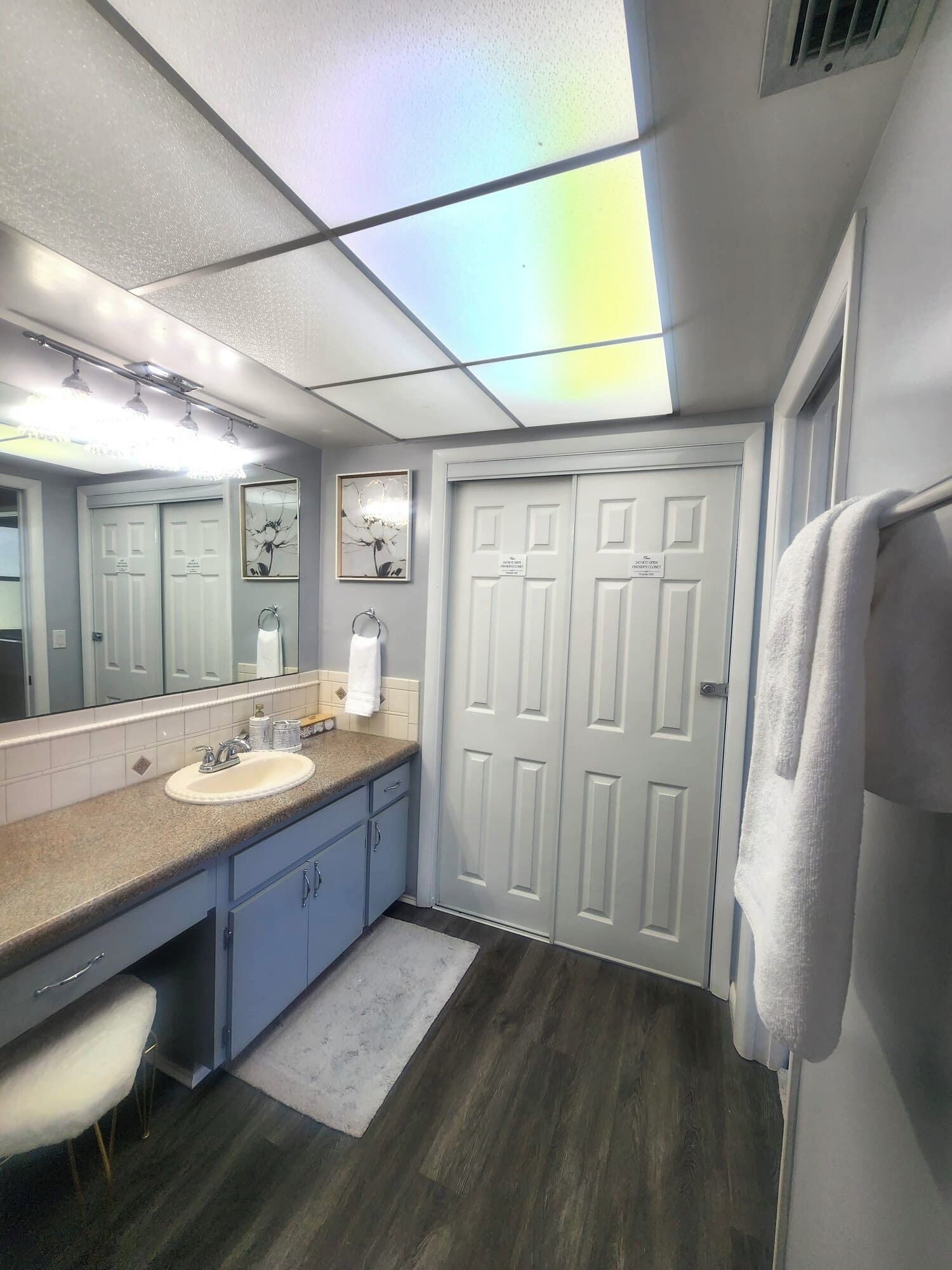 A bathroom with a sink, mirror, and two doors.