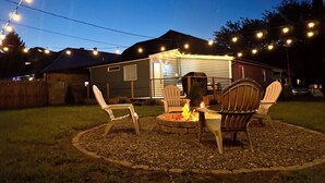 A backyard with a fire pit, outdoor furniture, and string lights. - Heart of Convenience Downtown near Convention Center-Lucas Oil-Fully Remodeled  (Indianapolis)