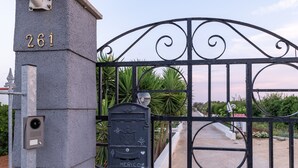 Una entrada tancada amb una closca de correu amb el nom 'Mericome Guadalajara', el número '261' en un pilar, i una porta metàl·lica.
