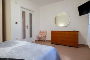 A bedroom with a bed, a dresser, a vanity, a mirror, and a television. - 'Bellavita and Pool' Apartment with Shared Pool, Wi-Fi and Air Conditioning (Brindisi)