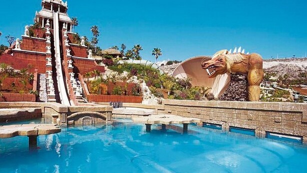 A pool with a water slide and a dinosaur statue. - Holiday Apartment 'Central Los Cristianos' with Mountain View, Pool and Wi-Fi (Los Cristianos)