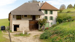 Ein zweigeschossiges Haus mit einer Schotterzufahrt und einem Holztor.