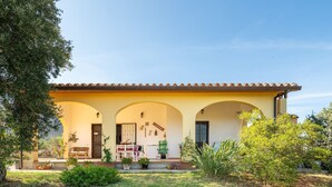 A house with a covered porch, a door, and a bench. - Villa 'Oliveto' with Mountain View, Private Terrace and Air Conditioning (Villa san pietro)
