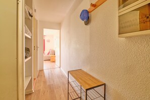 A hallway with a wooden table, a ceiling fan, and a door leading to another room. - Apartment 'Appartement Alpe D'huez' with Balcony (Huez)