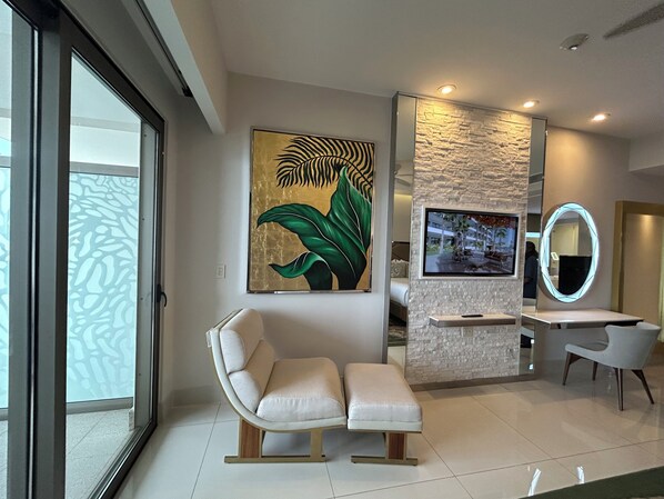 Un salon moderne avec un canapé, un téléviseur et un élément décoratif mural.