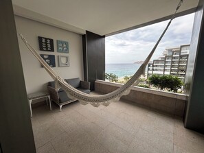 Un balcon avec un hamac, un canapé et une petite table.