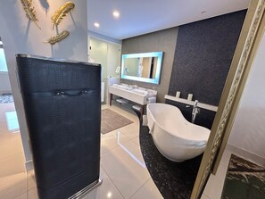Une salle de bain moderne avec une baignoire sur pieds, un meuble-lavabo avec un miroir et des éléments décoratifs sur les murs.