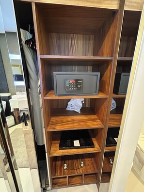 Une étagère en bois sur laquelle se trouvent un sèche-cheveux et un appareil électronique noir sur l’étagère supérieure.