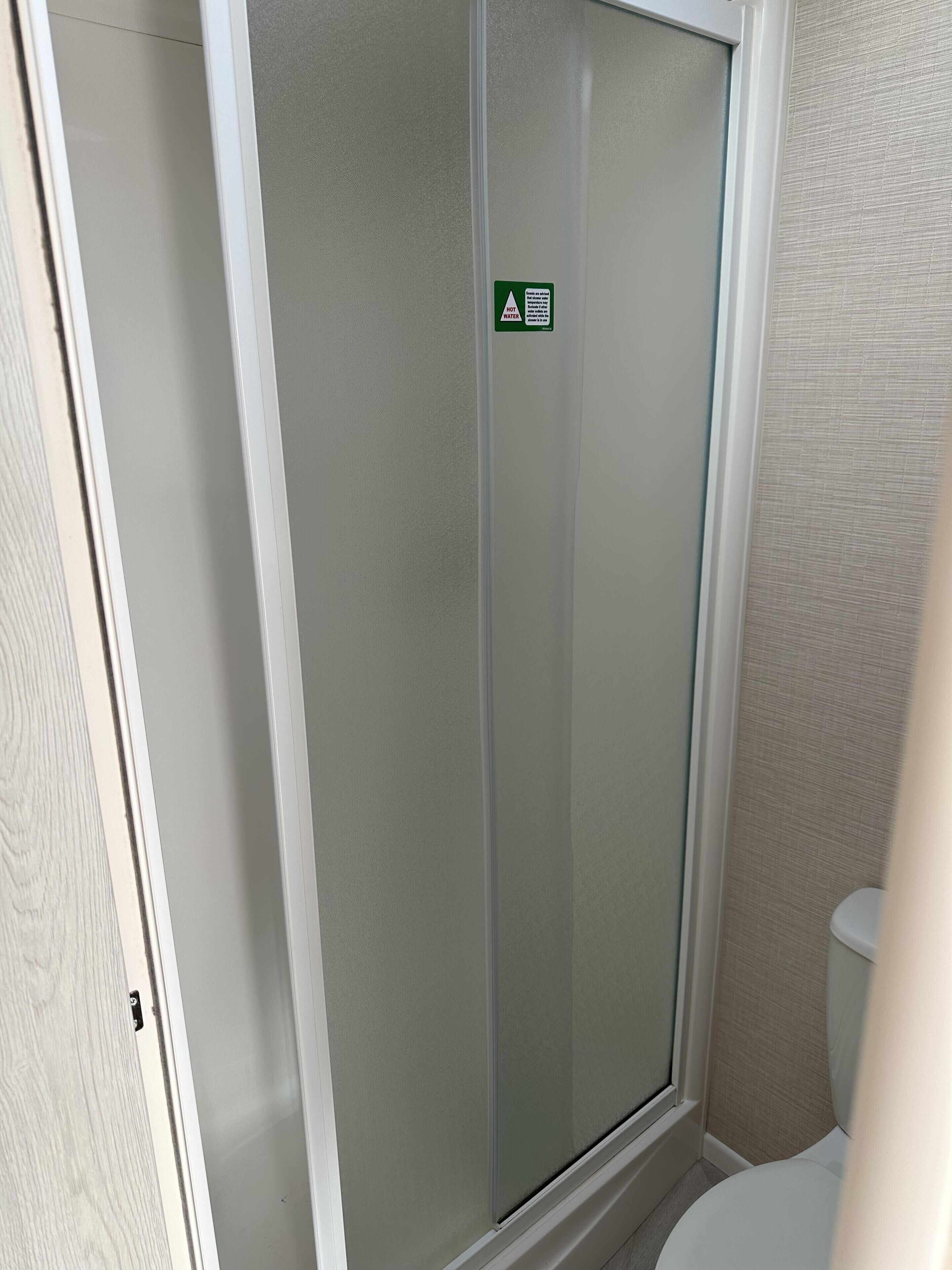 Une salle de bain avec une douche à parois de verre et des toilettes.