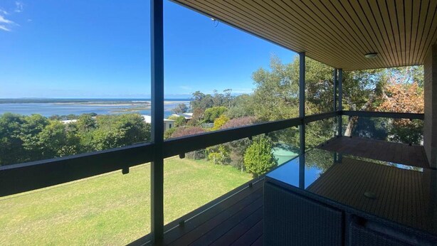A room with large windows offering a view of a body of water and surrounding greenery. - A perfect view of Gabo Island. (Mallacoota)