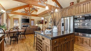 Una cocina amplia con armarios de madera, encimera de granito y electrodomésticos de acero inoxidable.