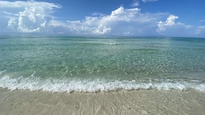 A beach with clear turquoise water and a sandy shore.