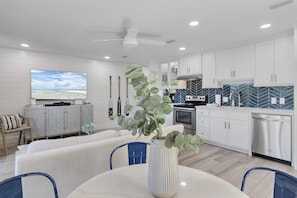 Relax in a spacious living area with a large flat-screen TV, comfortable seating, and a dining table.