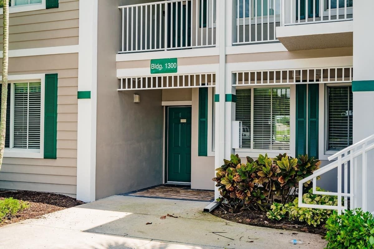A multi-story building with a green door and a sign reading "Bldg. 1300".