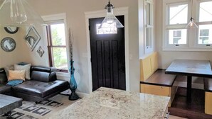 Een moderne keuken met een marmeren aanrecht, een eettafel en een ingebouwde bank.