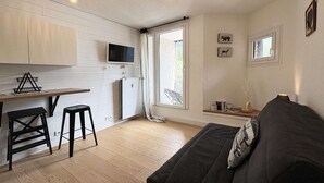 A compact living space with a kitchenette, a sofa, a TV, and a window with curtains. - 2-person studio with superb view of the slopes (LES ORRES 1650)