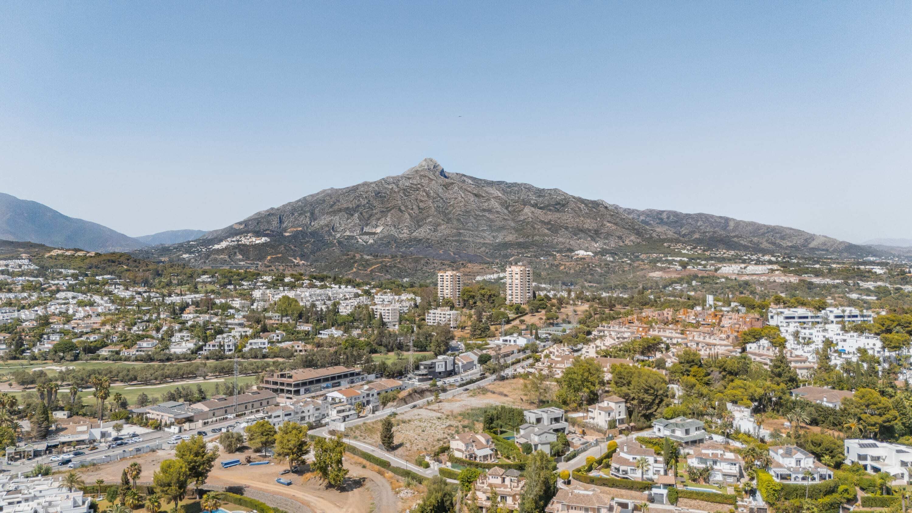 A residential area with a prominent mountain in the background, surrounded by houses and buildings.