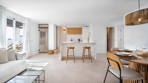 A modern apartment with a kitchen, dining area, and living room.